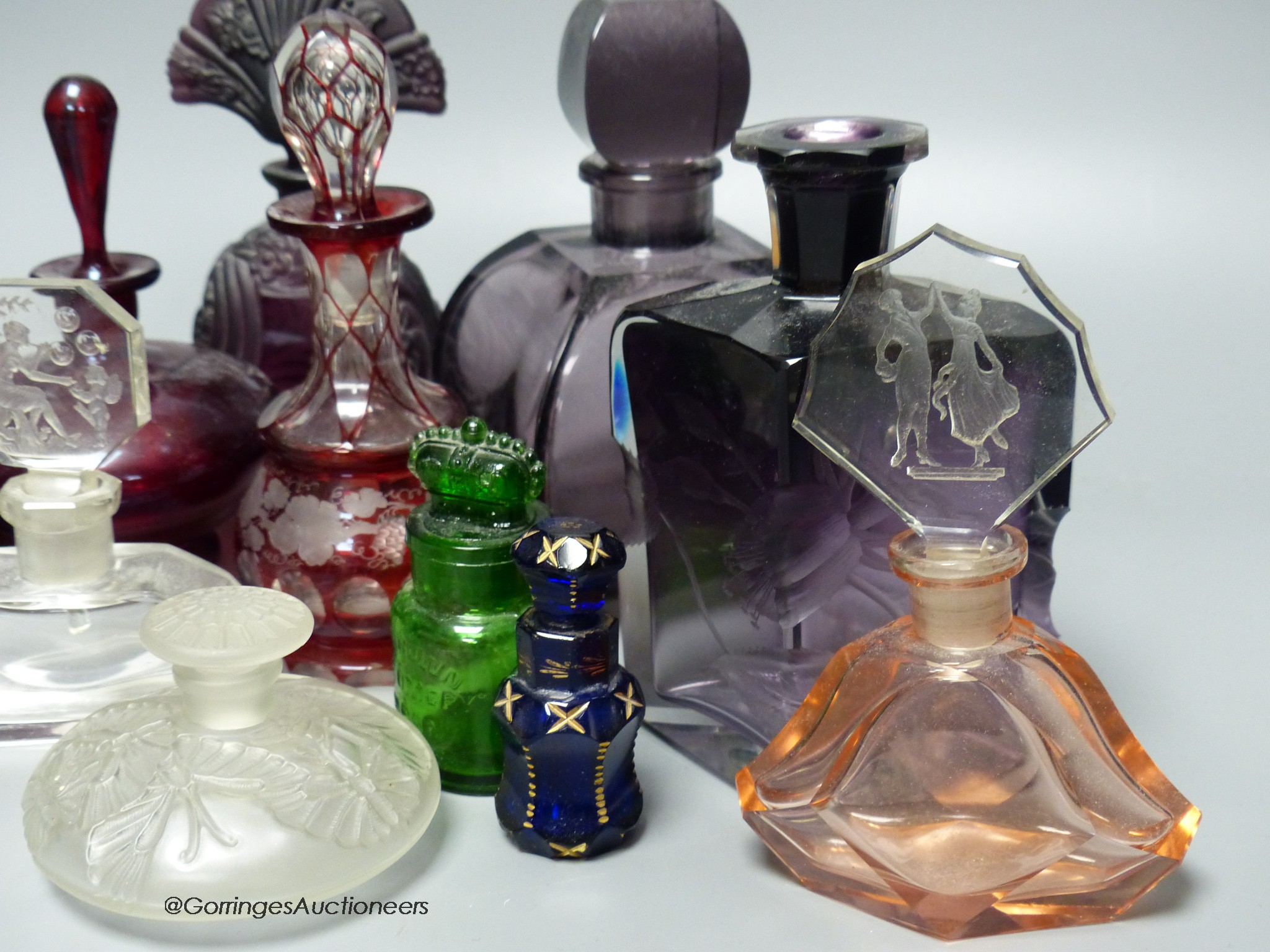 A collection of 1920's and earlier glass scent bottles to include ruby, amethyst, blue, clear and green